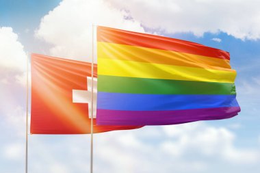 Sunny blue sky and flags of lgbt and switzerland