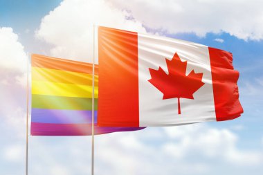 Sunny blue sky and flags of lgbt and canada