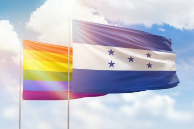 Sunny blue sky and flags of lgbt and honduras