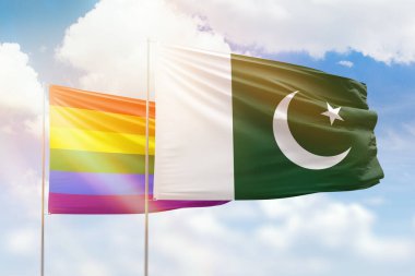 Sunny blue sky and flags of lgbt and pakistan