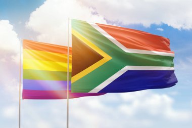 Sunny blue sky and flags of lgbt and south africa