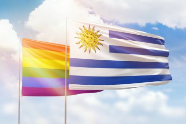 Sunny blue sky and flags of lgbt and uruguay