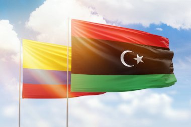 Sunny blue sky and flags of libya and colombia