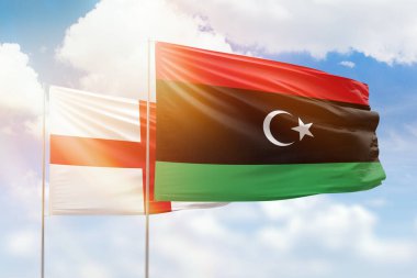 Sunny blue sky and flags of libya and england