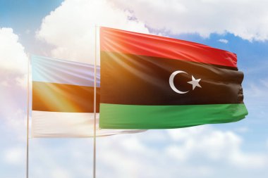 Sunny blue sky and flags of libya and estonia
