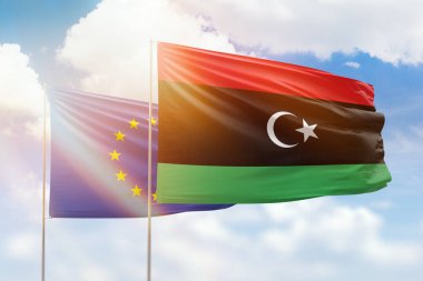 Sunny blue sky and flags of libya and european union