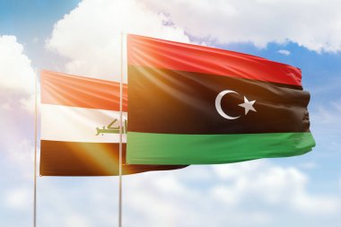 Sunny blue sky and flags of libya and iraq