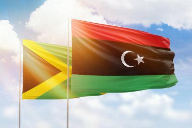 Sunny blue sky and flags of libya and jamaica