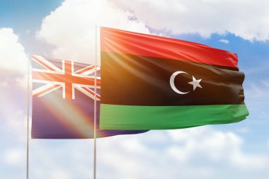 Sunny blue sky and flags of libya and new zealand