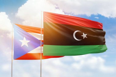 Sunny blue sky and flags of libya and puerto rico