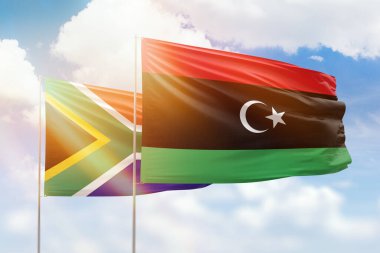 Sunny blue sky and flags of libya and south africa