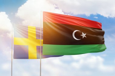 Sunny blue sky and flags of libya and sweden