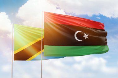 Sunny blue sky and flags of libya and tanzania