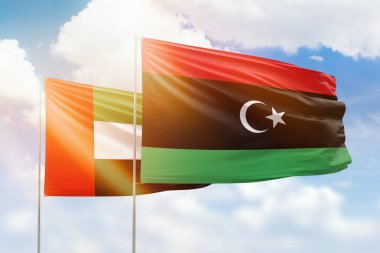 Sunny blue sky and flags of libya and uae