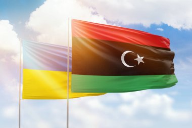 Sunny blue sky and flags of libya and ukraine