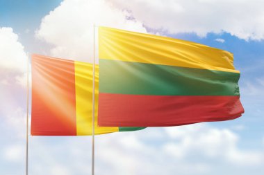 Sunny blue sky and flags of lithuania and guinea
