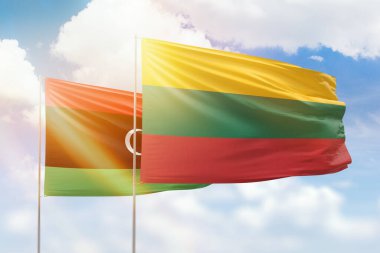 Sunny blue sky and flags of lithuania and libya