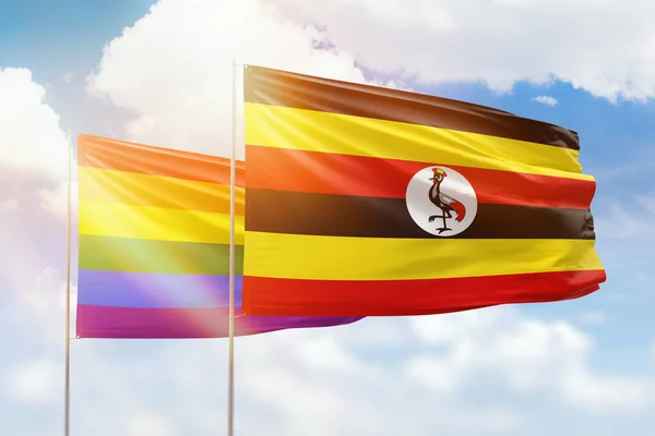 Sunny blue sky and flags of lgbt and uganda