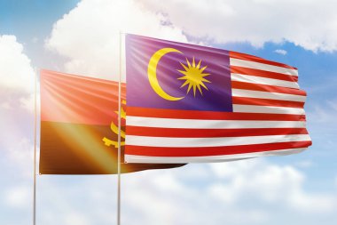 Sunny blue sky and flags of malaysia and angola