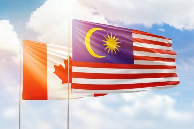Sunny blue sky and flags of malaysia and canada