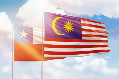 Sunny blue sky and flags of malaysia and chile