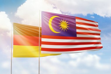 Sunny blue sky and flags of malaysia and germany