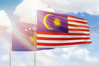 Sunny blue sky and flags of malaysia and kosovo