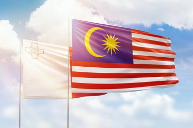 Sunny blue sky and flags of malaysia and malta