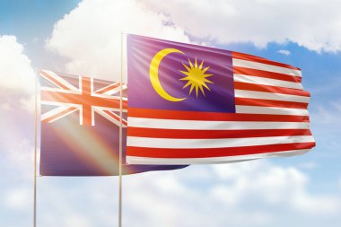 Sunny blue sky and flags of malaysia and new zealand