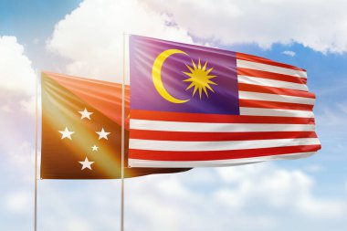 Sunny blue sky and flags of malaysia and papua new guinea