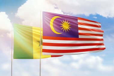 Sunny blue sky and flags of malaysia and senegal