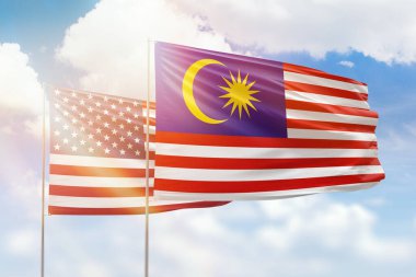 Sunny blue sky and flags of malaysia and usa