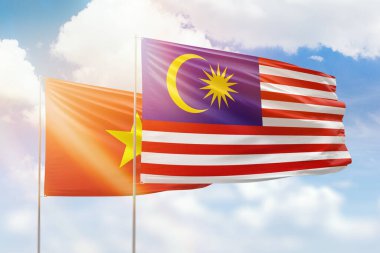 Sunny blue sky and flags of malaysia and vietnam