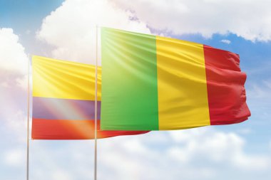 Sunny blue sky and flags of mali and colombia