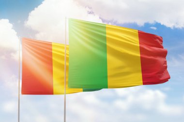 Sunny blue sky and flags of mali and guinea