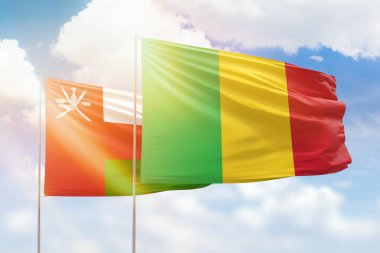 Sunny blue sky and flags of mali and oman