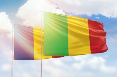 Sunny blue sky and flags of mali and romania