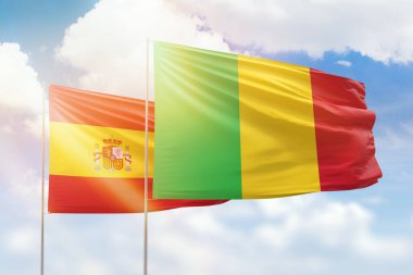 Sunny blue sky and flags of mali and spain