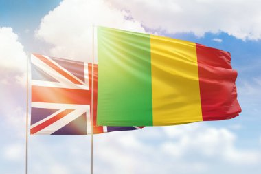 Sunny blue sky and flags of mali and united kingdom