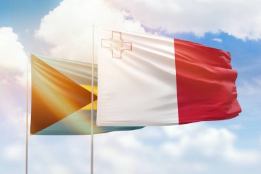 Sunny blue sky and flags of malta and bahamas