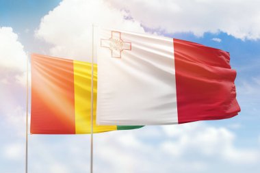 Sunny blue sky and flags of malta and guinea