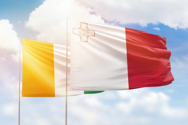 Sunny blue sky and flags of malta and ivory coast