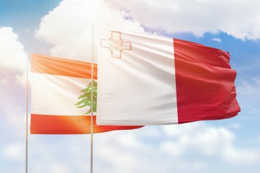 Sunny blue sky and flags of malta and lebanon
