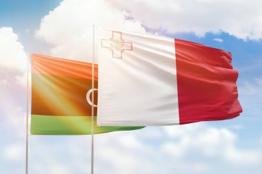 Sunny blue sky and flags of malta and libya