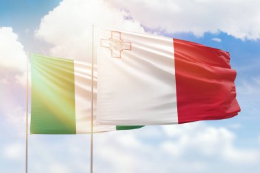 Sunny blue sky and flags of malta and nigeria