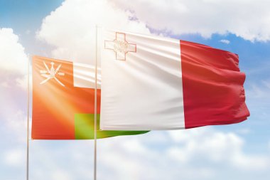Sunny blue sky and flags of malta and oman
