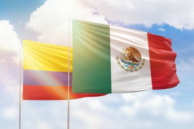 Sunny blue sky and flags of mexico and colombia