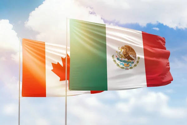 Sunny blue sky and flags of mexico and canada