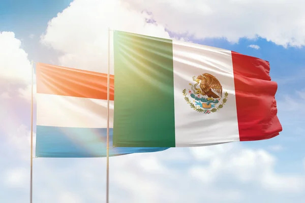 Sunny blue sky and flags of mexico and luxembourg