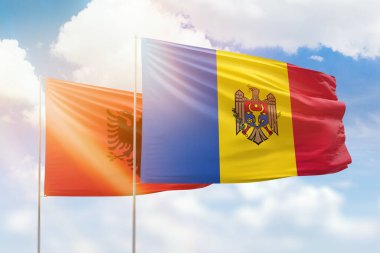 Sunny blue sky and flags of moldova and albania